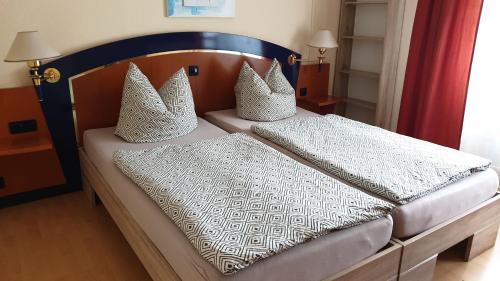 Una cama con sábanas blancas y almohadas. en Ferienhaus grüne Oase en Halle an der Saale