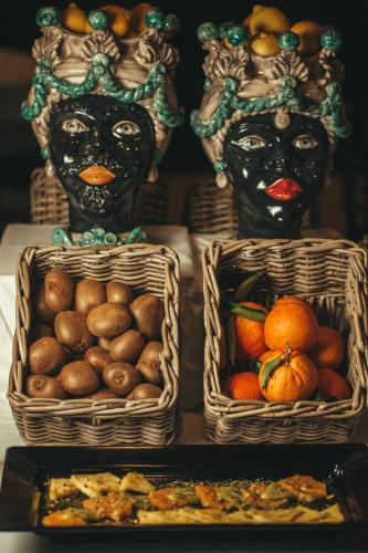 three baskets of fruit with face painted on them at Alba Palace Hotel in Favara