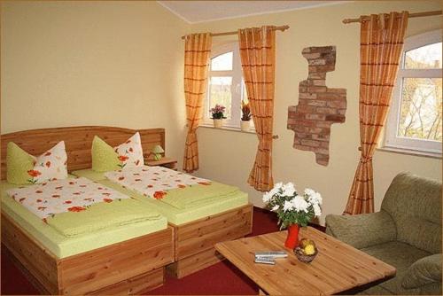 a bedroom with a bed and a couch and a table at Landhotel zum Honigdieb in Ribnitz-Damgarten