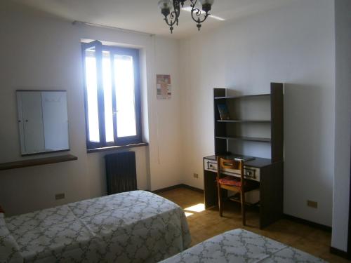 a bedroom with a bed and a desk and a window at CASA IN RIVA AL LAGO in Varenna