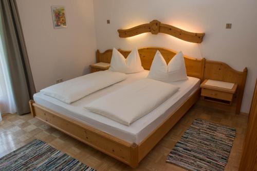 a bedroom with a wooden bed with white pillows at Ferienhaus Franz in Weissbriach