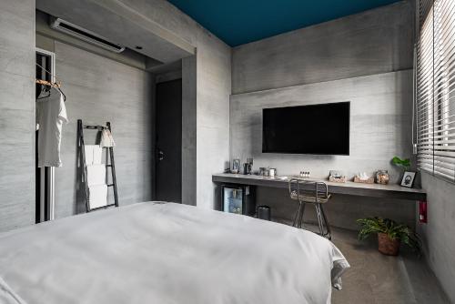 Schlafzimmer mit einem Bett und einem Flachbild-TV in der Unterkunft Loft Inn in Altstadt von Hengchun