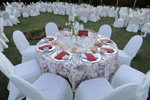 a table set up for a wedding with white tables and chairs at Hotel Vegas Altas in Don Benito