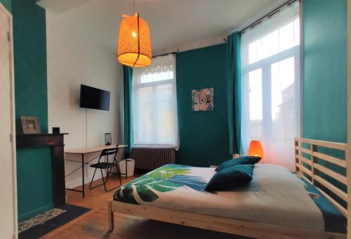 a bedroom with green walls and a bed and a desk at Résidence MUSEE-HOME - Centre ville Valenciennes in Valenciennes