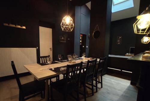 une salle à manger avec une longue table et des chaises dans l'établissement Résidence MUSEE-HOME - Centre ville Valenciennes, à Valenciennes
