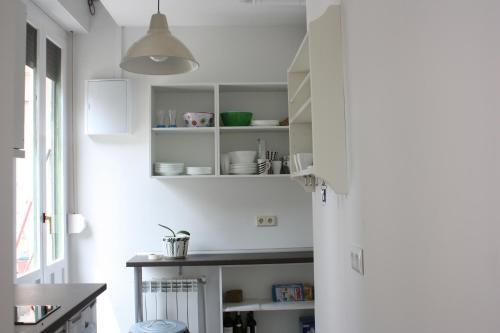 a kitchen with white cabinets and a table at Aloha Hostel in Pamplona