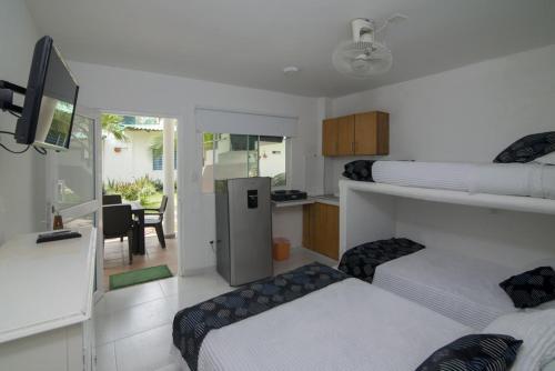 1 dormitorio con 2 camas y cocina con comedor en Habitacion Coveñitas 6, en Coveñas