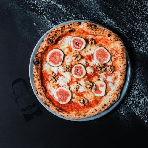 a pizza with pepperoni and mushrooms on a table at Hotel Babula am Augarten in Vienna