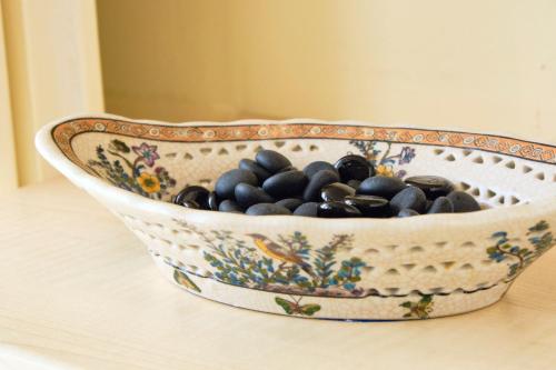 a bowl filled with black rocks sitting on a table at Casa Rubinacci in Naples