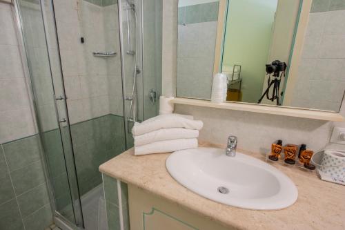 un bagno con lavandino e doccia di Alma Resort a Castiadas