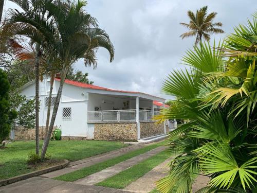 a white building with palm trees in front of it at La Toscana in Chinauta