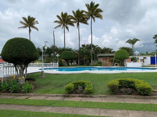 a swimming pool in a resort with palm trees at La Toscana in Chinauta