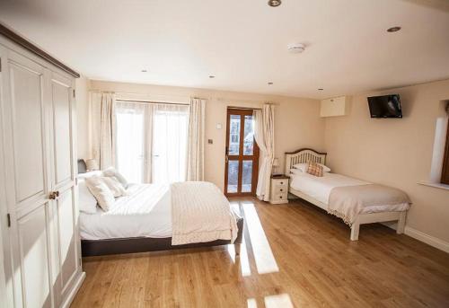 1 dormitorio con 2 camas y ventana grande en Hillcroft Accommodation, en Redhill