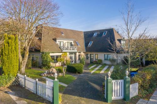 una casa con una valla blanca y un patio en Seehof Boutique Appartements, en Büsum