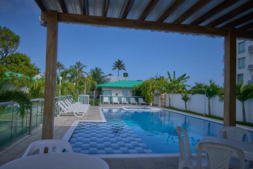vista sulla piscina di un resort con sedie bianche di Apartamento Coveñitas 8 a Coveñas