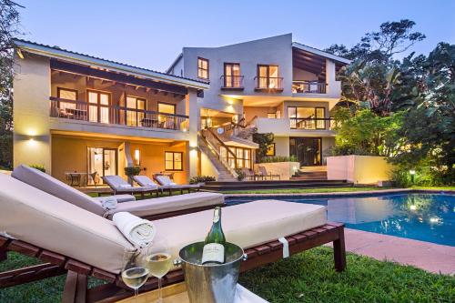 a home with a swimming pool and a house at Teremok Lodge & Spa in Durban