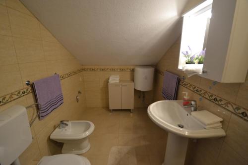 un piccolo bagno con lavandino e servizi igienici di Apartmani Antonia Nakić -Stobreč a Spalato (Split)