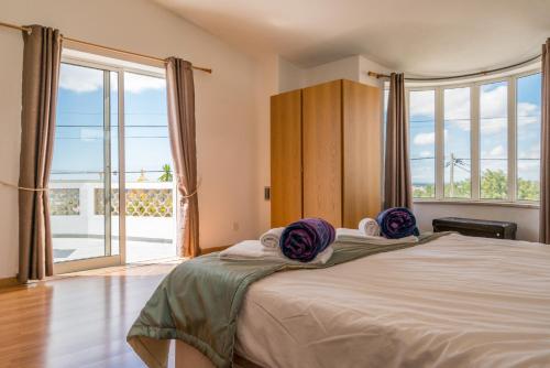 a bedroom with a large bed with a large window at Casa Laranja Three bedroom Villa in Loulé