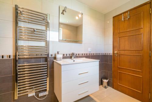 a bathroom with a sink and a wooden door at Casa Laranja Three bedroom Villa in Loulé
