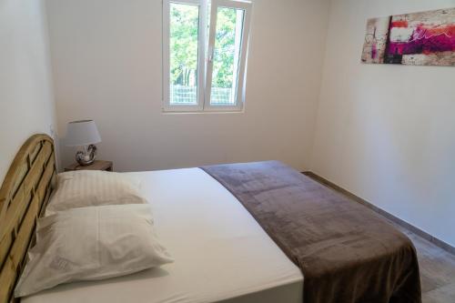 ギソナクシアにあるA Suaraの窓付きの白い部屋のベッド1台