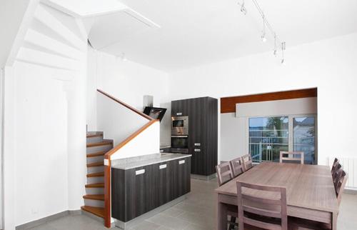 une cuisine et une salle à manger avec une table et des chaises dans l'établissement VVF Résidence Golfe du Morbihan, à Larmor-Baden