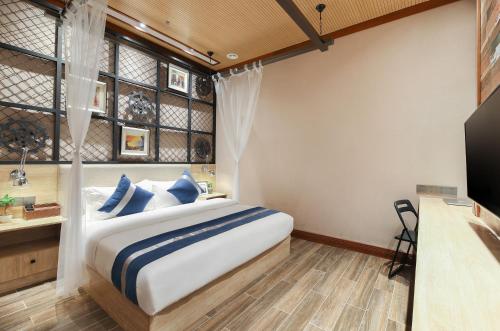 a bedroom with a bed with blue and white pillows at Zou Qu Ye Travel Hotel in Chongqing