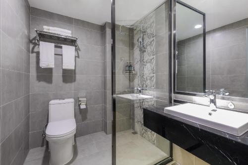 a bathroom with a toilet and a sink at Zou Qu Ye Travel Hotel in Chongqing