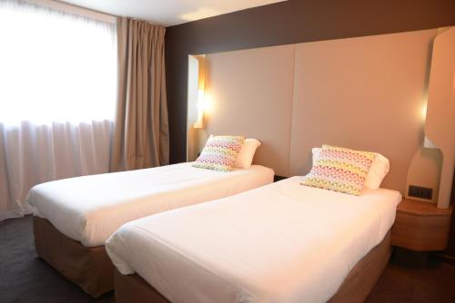 una camera d'albergo con due letti e una finestra di Campanile SETE - Balaruc a Balaruc-le-Vieux