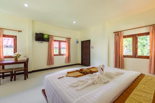 a bedroom with a large bed with a robe on it at Green Garden House in Ao Nam Mao