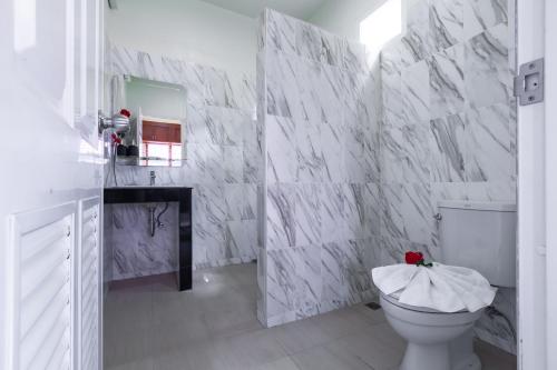 a bathroom with white marble walls and a toilet at Green Garden House in Ao Nam Mao