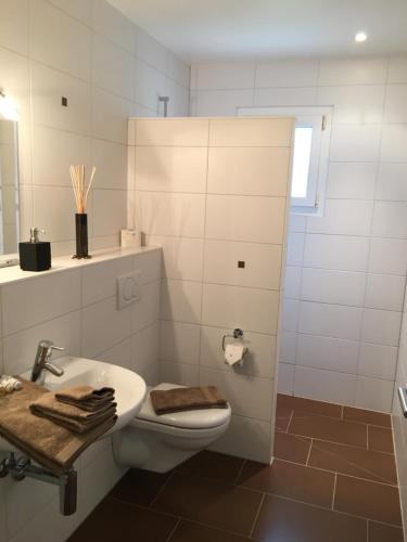 een witte badkamer met een toilet en een wastafel bij Montaney Guests House - EPFL in Ecublens