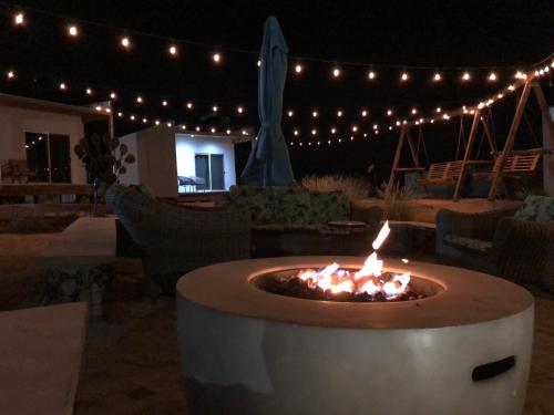 a fire pit in the middle of a patio with lights at Rincón del Corazón in Valle de Guadalupe