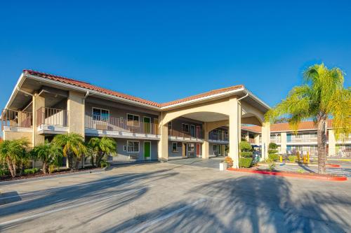 a large building with palm trees in front of it at Signature Temecula in Temecula