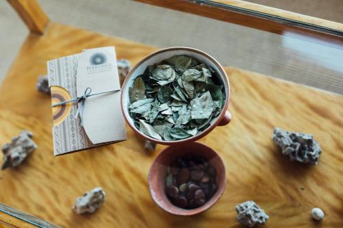 a cup of dried leaves on a table with a bowl of nuts at Ecolodge La Estancia in Comunidad Yumani