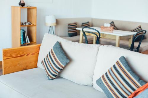 a living room with a white couch with two pillows at Ecolodge La Estancia in Comunidad Yumani