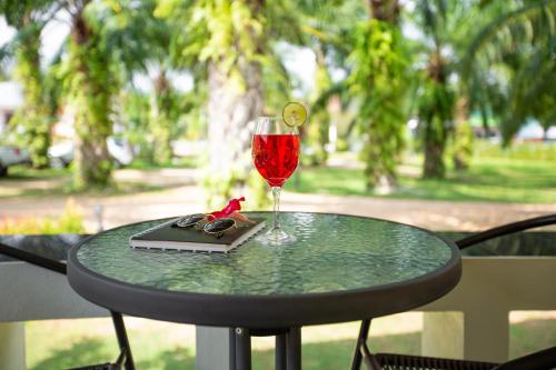 a glass of wine and a book on a table at Green Garden House in Ao Nam Mao