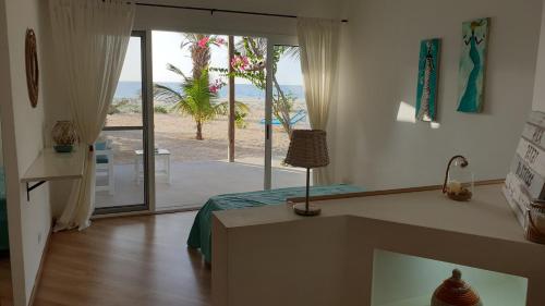 Beachhaus Praia de Chaves في Cabeçadas: غرفة نوم بسرير وإطلالة على الشاطئ