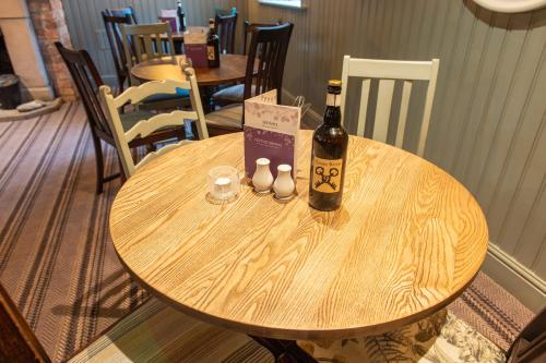 a bottle of wine sitting on top of a wooden table at Cross Keys by Chef & Brewer Collection in Nunthorpe