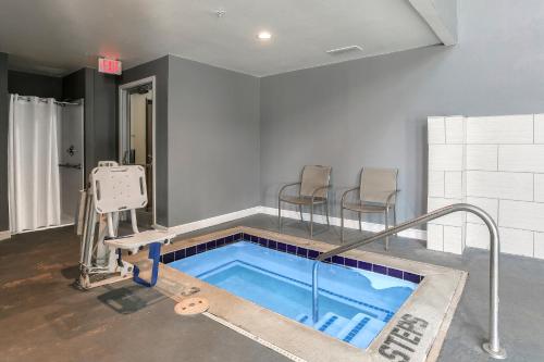 - une piscine pour la nage en longueur dans une pièce entourée de chaises dans l'établissement Baymont by Wyndham Bowling Green, à Bowling Green