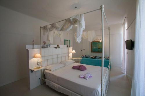 a bedroom with a white bed with a canopy at A Casa di LoLu in Grottammare