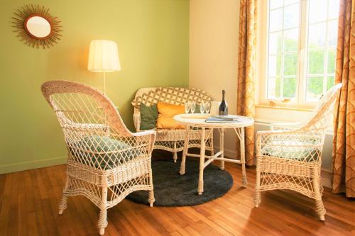 a living room with wicker chairs and a table at Les belles vignes in Vouvray