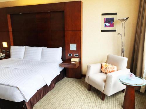 a hotel room with a bed and a chair at Swissotel Quito in Quito