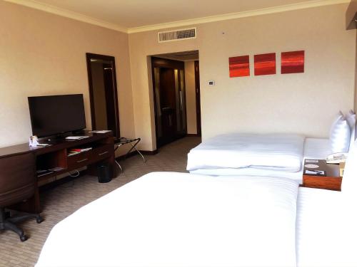 a hotel room with a bed and a desk with a television at Swissotel Quito in Quito