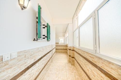 a hallway with large windows and a tiled floor at Chandris Apartments in Kavos