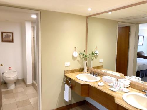 a bathroom with two sinks and a large mirror at Swissotel Quito in Quito