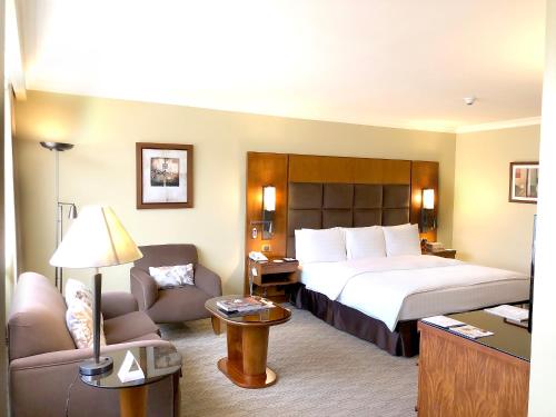 a hotel room with a large bed and a couch at Swissotel Quito in Quito