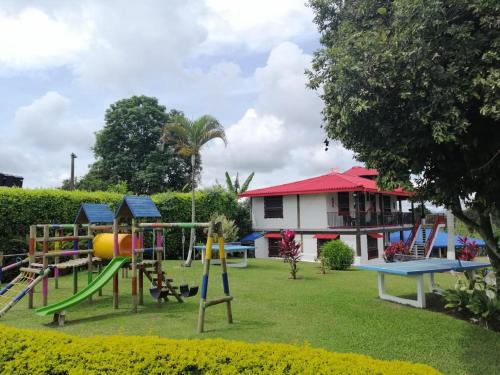 a playground in front of a house at Finca Hotel la Manuela in Armenia