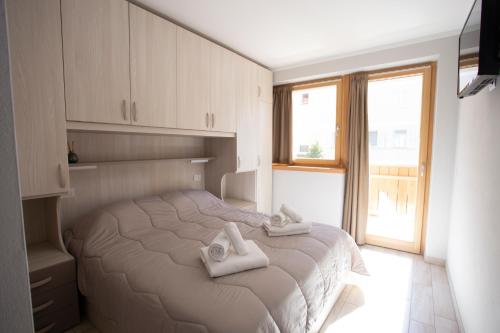 a bedroom with a bed with towels on it at Perla delle Dolomiti in Andalo
