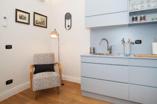 a kitchen with a chair and a sink at LikeYourHome, 80 sq m luxury apartment with Jacuzzi, in Trastevere district in Rome