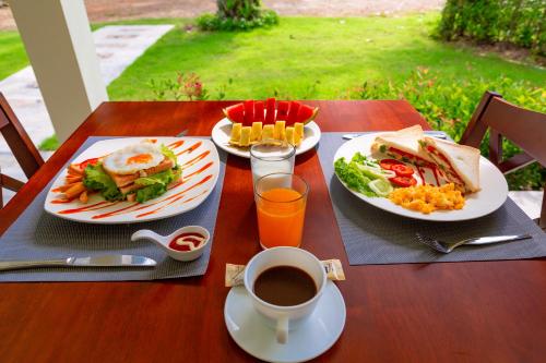 a table with two plates of food and a cup of coffee at Green Garden House in Ao Nam Mao